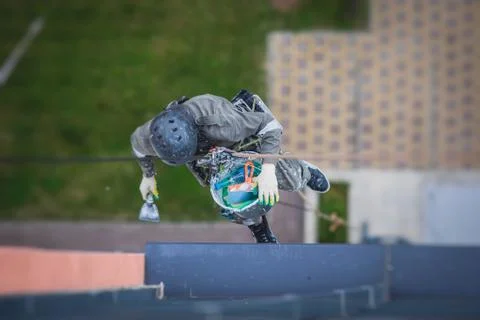 Professional climber rope access worker painting and repairing the facade of  Stock Photos
