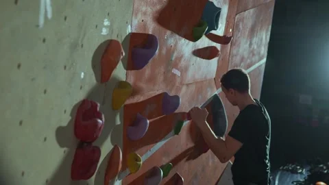 A professional climber trains at a climbing wall, practices rock climbing Stock Footage 241068258