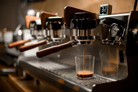 Professional coffee machine automatically prepares and pours espresso drink into 스톡 사진