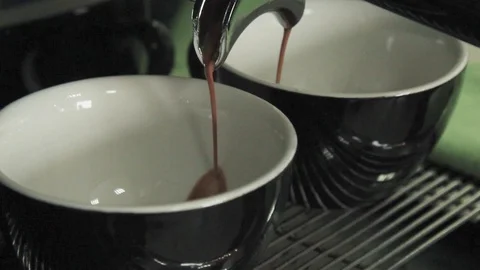 Professional coffee machine makes coffee in two black and white mugs Stock Footage 105460019