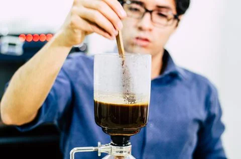 Professional coffee maker - Barista using coffee siphon brewing hot espresso at Stock Photos