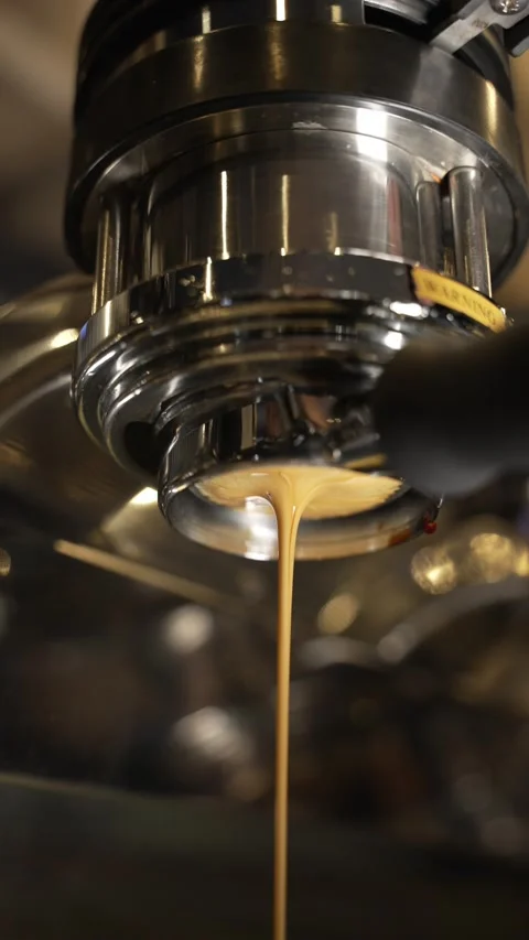 Professional coffee maker pours coffee into a cup from the spouts portafilter. Video stock 220066820