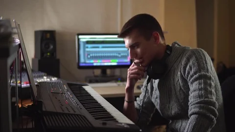 A professional composer composes music on an electronic piano in the Studio Stock Footage 72289375