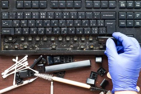 A professional computer technician removes keys from an computer keyboard Stock Photos