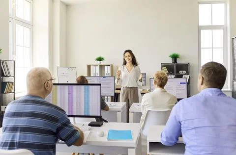 Professional computer training class with instructor and adult students in Stock Photos