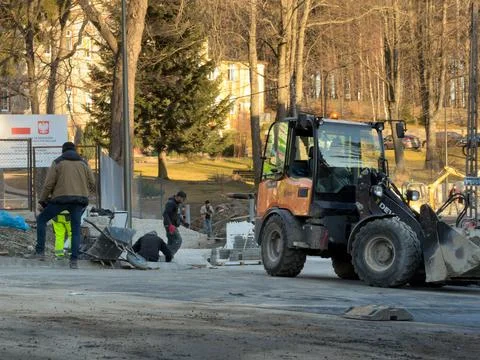A professional construction crew operates a yellow loader on a road development Stock Photos