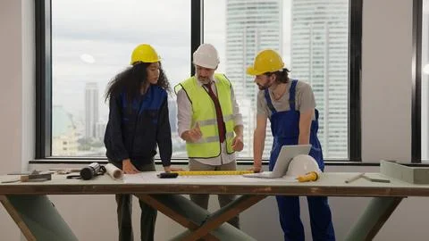 Professional construction engineers team using blueprint of project plan Stock Photos