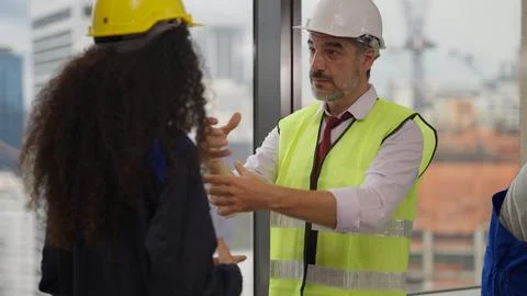 Professional construction engineers team using blueprint of project plan Stock Photos