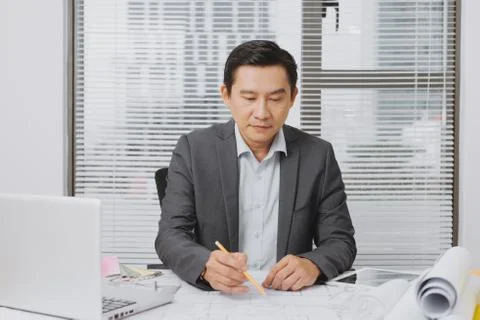 Professional construction manager working with blue print in office Stock Photos
