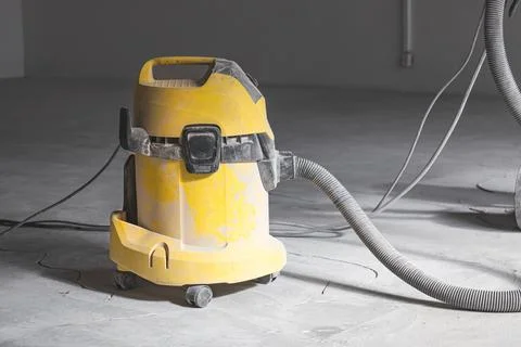 Professional construction vacuum cleaner at work, warehouse repair Stock Photos