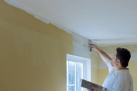 Professional construction worker applying plaster coating to the freshly plas Stock Photos