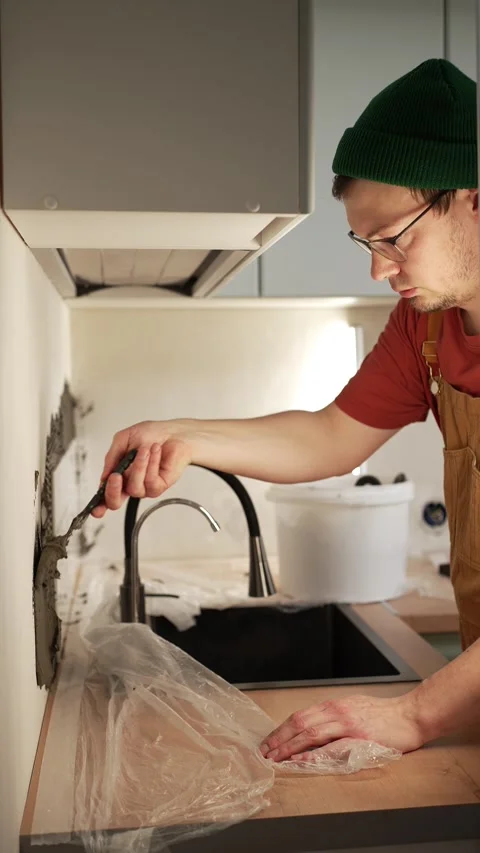 Professional construction worker applying tile adhesive mortar to the kitchen Stock Footage 344565129