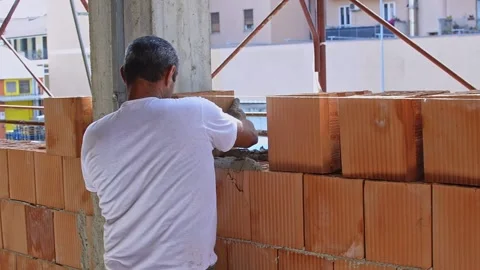 Professional construction worker building brick walls with cement and mortar 動画素材 283461059