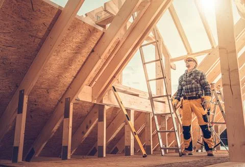 Professional Construction Worker Inside Newly Built Wooden Frame House Foto stock