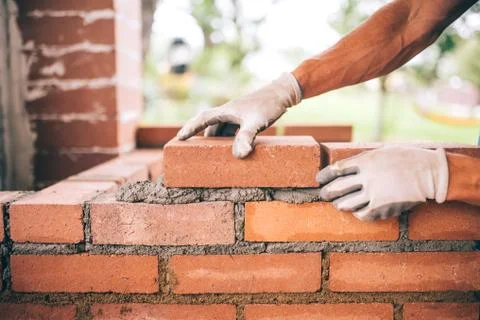 Professional construction worker laying bricks and building barbecue Stock Photos