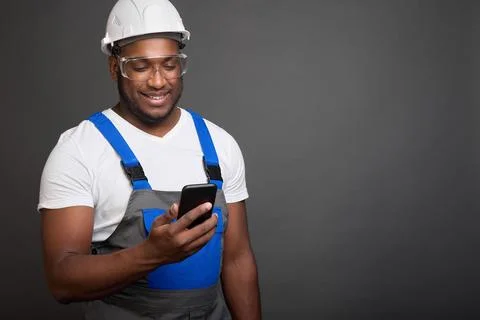 Professional construction worker in protective helmet and glasses corresponds Stock Photos