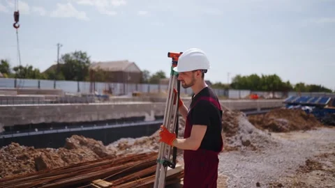 Professional Construction Worker Using Theodolite Surveying Optical Instrument Stock Footage 258798728