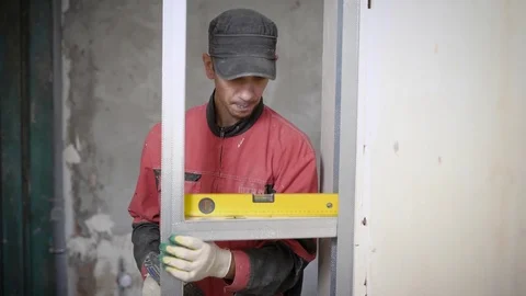 Professional constructor using leveling gauge for measuring on building site Vídeos de archivo 82991621