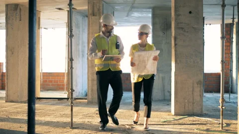 Professional constructors discuss construction plan. Steadicam shot. Vídeos de archivo 95037298