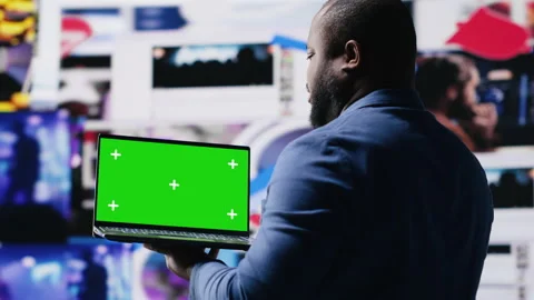 Professional content creator in a multitasking space holds green screen Stock Footage 312300006