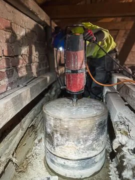Professional contractor core drilling large hole in reinforced concrete. Stock Photos