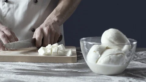 Professional cook chopping mozzarella cheese on the cutting board Stock Footage 127414635