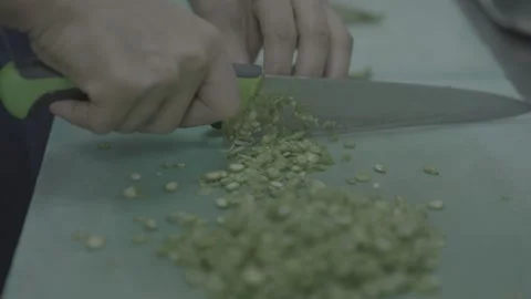 Professional cook dicing vegetables on a green cutting board 스톡 동영상 327356014