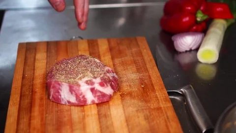 Professional cook kitchen chef marinating thick slice of raw beef steak meat on Video stock 105456853