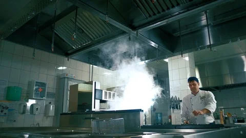 Professional cook in the kitchen sets fire to the pan and fry meat Stock Footage 102661042