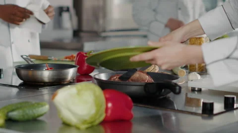 Professional cook preparing beef steak in frying pan on kitchen stove Stock Footage 188710237