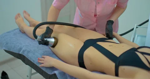 Professional cosmetologist does a hardware vacuum massage to a young woman Stock Footage 125402484