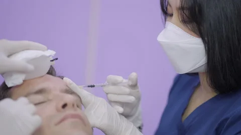 Professional cosmetologist making injection of botulinum toxin into face of Video stock 205901007