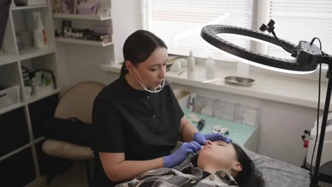 Professional cosmetologist performing a lip blushing permanent makeup procedure Stock Footage 327150547