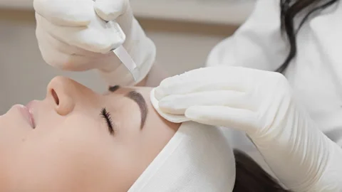 Professional cosmetologist performing microblading procedure on young womans Stock Footage 341038803