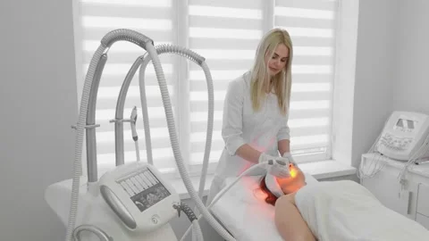 A professional cosmetologist performs a modern laser facial treatment for a 库存影片 341032586