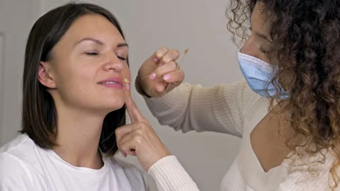 Professional cosmetologist performs wax epilation on the patient's upper lip. Video stock 161398508