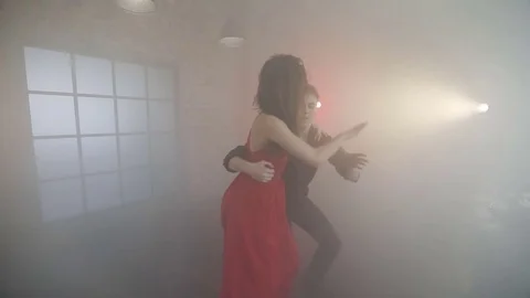 Professional couple dancing tango in the smoke in the studio. Stock Footage 76463433