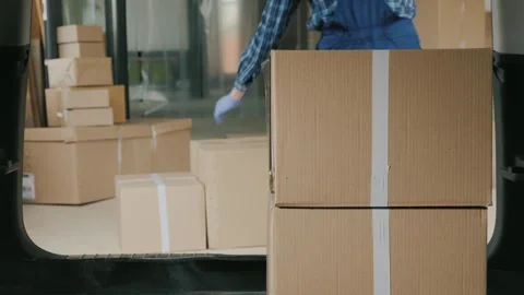 Professional courier loading cardboard boxes into vehicle trunk for express.. Stock Footage 334638855