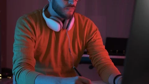 Professional creative man freelancer working on device indoors colourful neon Video stock 126578531