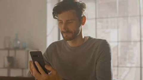 Professional Creative Man Sitting at His Desk in Home Studio Using Smartphone 스톡 동영상 111621856