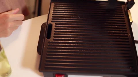 Professional culinary expert greasing searing hot electric grill surface us.. Stock Footage 307496089