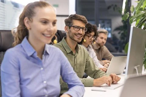 Professional customer support agent man in assisting customers at call center Stock Photos
