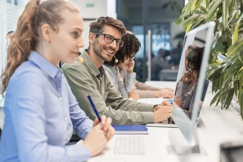 Professional customer support agent man in assisting customers at call center Foto stock