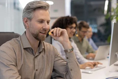 Professional customer support agent man in assisting customers at call center Stock Photos