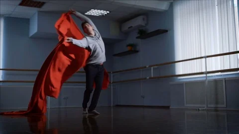 Professional dancer finishes his dance of beautiful wave of red cloth in front Stock Footage 70366180