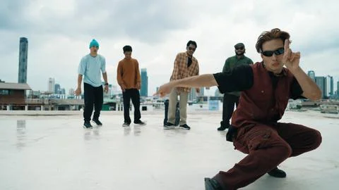 Professional dancer practice B boy dance with friends at roof top. Endeavor. Stock Photos