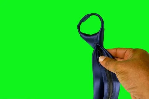 Professional dark skinned hand adjusting a zipper tie on vibrant green screen Foto stock