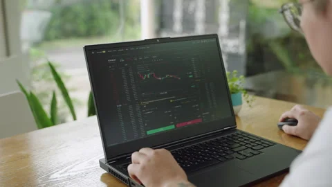 Professional day trader analyzes realtime chart data on laptop in modern office Stock Footage 270539394