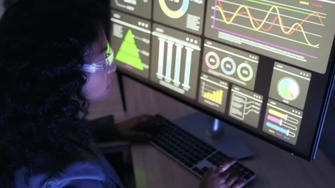 Professional at a desk analyzing interactive data dashboards on a large monitor 스톡 동영상 327358842