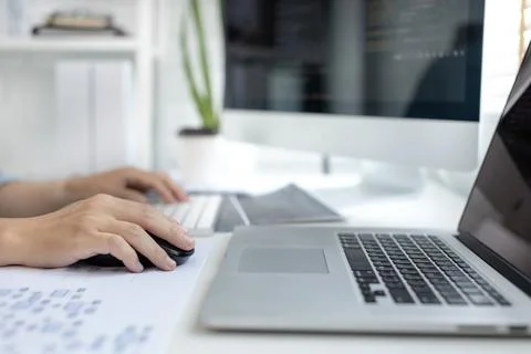 Professional development programmers are sit on a desk with work equipment su Stock-Fotos